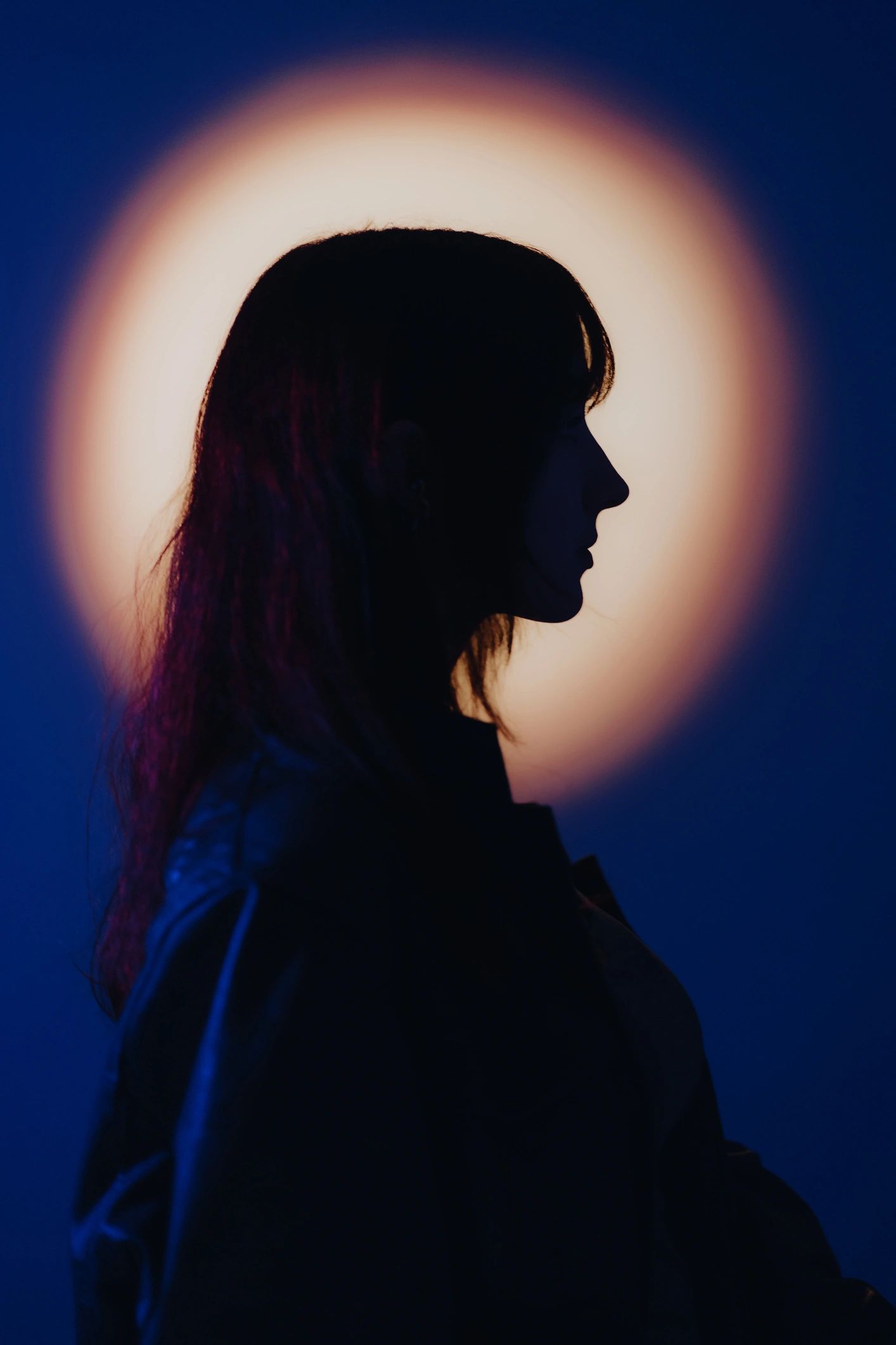 Silhouette portrait against orange and purple background